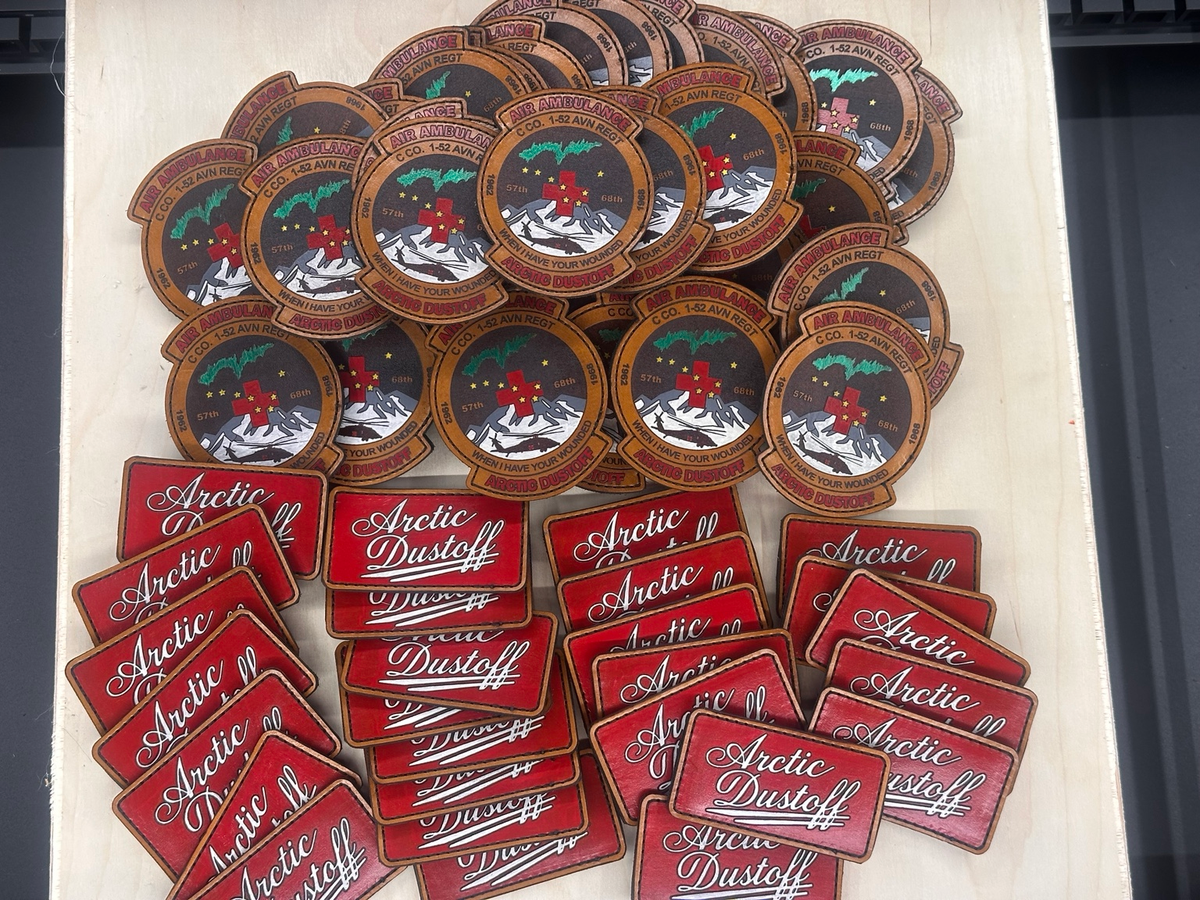 Hand-painted Arctic Dustoff full-grain leather military unit patches arranged in a batch